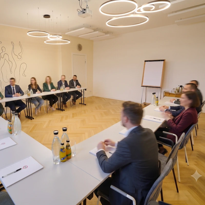 meeting-800 Menschen mit und ohne Krawatten sitzen an einem großen Tisch-U in einer Besprechung bei Meeet in Berlin Wilmerdorf